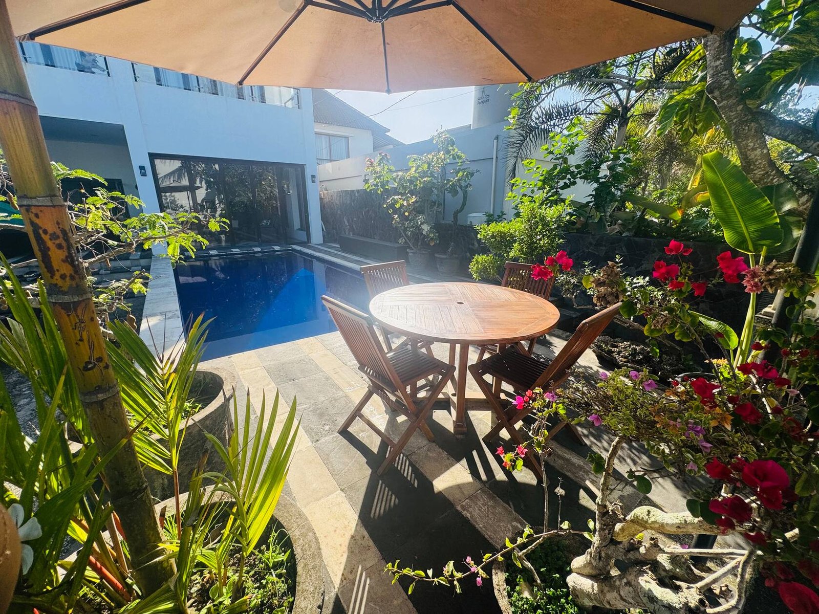 Teak table by the pool under the parasol