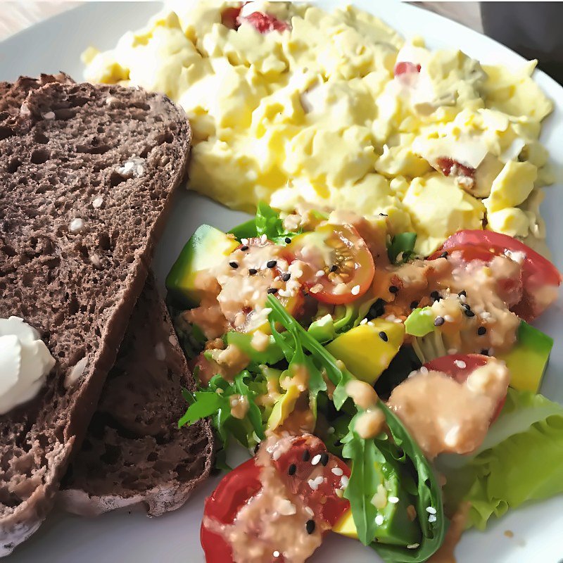 Breakfast plate with slices of our sourdough, scrambled eggs, avocado and a fresh salad